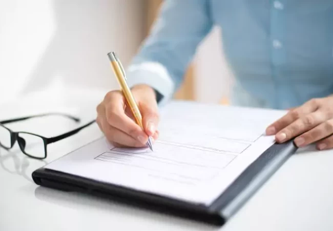 A woman is writing on a piece of paper