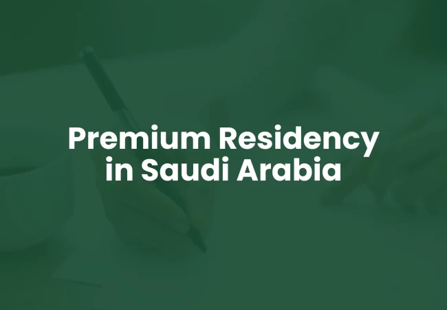 A hand holding a pen with text overlay "Premium Residency in Saudi Arabia"